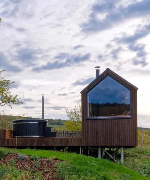 prefabricated timber micro-cabin extends living into the hungarian landscape